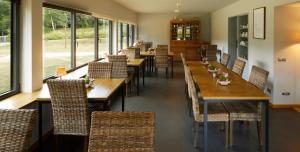 坎普罗东Hotelet Del Bac的餐厅设有木桌、椅子和窗户。