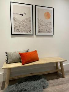 伦敦Brand new 3-bedroom home in London的一张木凳,墙上挂着三张照片