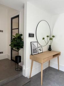 伦敦Brand new 3-bedroom home in London的墙上设有桌子和镜子的房间
