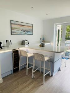 彼得伯勒Hampton Vale, Peterborough Lakeside Large Double bedroom with own bathroom的厨房配有带2把椅子和1张桌子的柜台