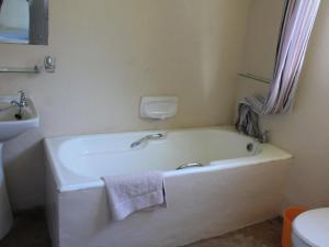 MpumeTHE HAVEN HOTEL的浴室配有白色浴缸及水槽