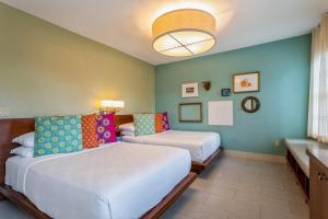 迈阿密海滩Kasa El Paseo Miami Beach的酒店客房设有两张床和窗户。