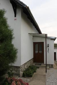 比托福Domek u lesa的一间白色的小房子,设有棕色的门