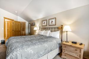 铜山Copper Springs的一间卧室配有一张床和一个带两盏灯的木制梳妆台。