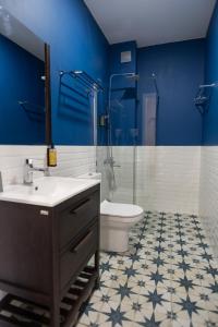 谢赫维蒂利Buxus Hotel Shekvetili的一间带水槽和卫生间的浴室以及蓝色的墙壁。