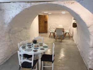 蒙特弗里奥Casa Montefrio的一间配备有白色桌椅的用餐室