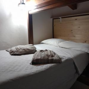 PescosansonescoCase Mastro Renzo tour naturalistico enogastronomico的卧室配有一张白色大床和木制床头板