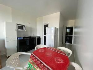 巴拉那州蓬塔尔Condominio Boa Vista的厨房配有桌椅和冰箱。