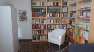 摩德纳Casa Braglia的书架前的图书馆,有白色椅子