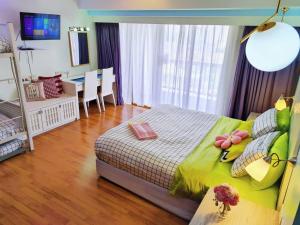 八打灵再也Exclusive Family Suites 5-6 Pax @ Sunway Pyramid的一间卧室配有一张带绿色棉被的床