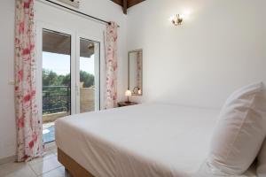 蒂锡利维Casa Callianeira Residence的一间白色卧室,配有床和阳台