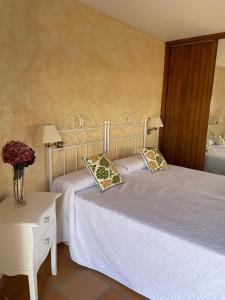 洛萨尔德拉韦拉CASA SEBASTIANA SUITE的一间卧室配有两张床和一张带两盏灯的桌子。