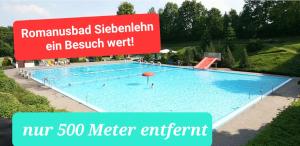 SiebenlehnPrivatzimmer的前面有一个标志的大型游泳池
