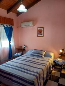GualeguaychúComplejo Aguas Termales的一间卧室配有一张带蓝白色毯子的床