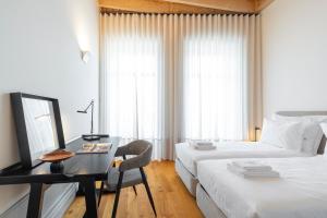 波尔图Mouzinho Village River的酒店客房配有书桌、床、床和书桌。
