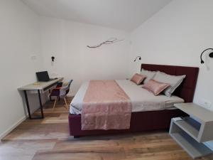 苏提万Apartment Dalmatia Holidays Adventure的一间卧室配有一张床和一张带笔记本电脑的书桌