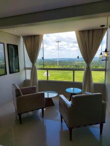 巴西利亚科罗拉多汽车旅馆（仅限成人）的客厅配有两把椅子和大窗户