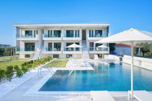 萨索斯Olia Thassos - Luxury Apartments的一座设有游泳池和遮阳伞的酒店