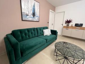 扎达尔ZADAR Panorama Sea View Apartments的客厅配有一张绿色沙发,设有一张桌子