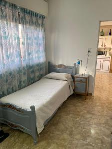 罗萨里奥CASA DEL NARANJO的一间卧室配有一张带窗帘和桌子的床