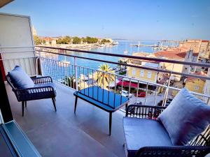 扎达尔ZADAR Panorama Sea View Apartments的阳台配有椅子,享有水景