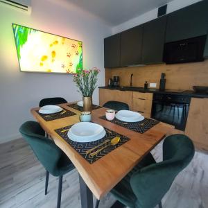 济夫努夫Haus am Meer Dziwnówek的一张带绿色椅子的木桌和厨房