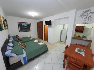 伊瓜苏港Charaí Lodge的一间卧室配有一张床铺和一张桌子,还设有一间厨房