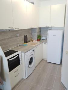 比亚拉Silver Beach B16的厨房配有洗衣机和冰箱。