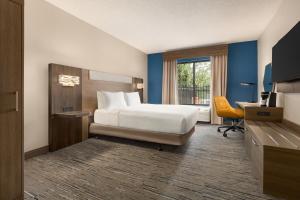 格林维尔Holiday Inn Express & Suites Greenville-Downtown, an IHG Hotel的配有一张床、一张书桌和一扇窗户的酒店客房