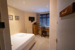 拉夫堡坎贝尔酒店的一间卧室配有一张床、一张书桌和一个窗户。