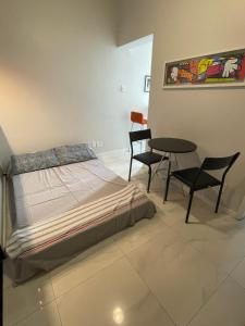 里约热内卢Lindo apartamento em Copacabana的卧室配有一张床和一张桌子及椅子