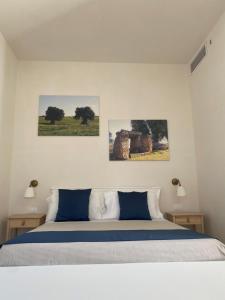 奥斯图尼Borgo Santuri的卧室配有一张墙上三幅照片的床