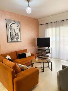 阿加迪尔Marina Agadir appartement standing 90m2 + piscine的客厅配有2张沙发和1台平面电视