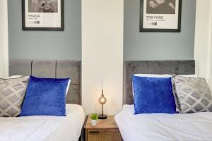 赫尔A Gem in Central Hull - Sleeps 6的卧室内的两张床和蓝色枕头