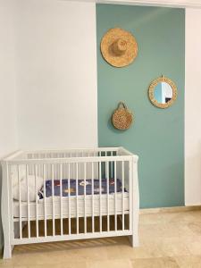 阿加迪尔Marina Agadir appartement standing 90m2 + piscine的蓝色墙壁的房间里一张白色的婴儿床