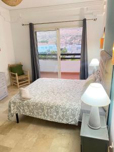 阿加迪尔Marina Agadir appartement standing 90m2 + piscine的一间卧室设有一张床和一个大窗户