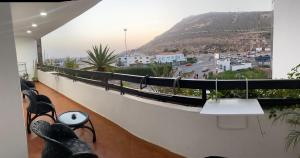 阿加迪尔Marina Agadir appartement standing 90m2 + piscine的坐在山景阳台上的人