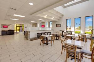 格尔夫波特Red Roof Inn Gulfport - Biloxi Airport的餐厅内带桌椅的用餐区