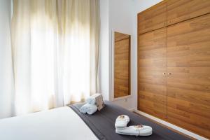 马拉加Minimal Rooms by ELE Apartments的一间卧室,配有一张床,上面有两双鞋