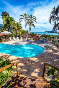 伊利亚贝拉Pousada Altamira的棕榈树和海洋度假村内的游泳池