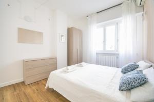 罗马Vacanze Romane Apartment的一间卧室配有白色床和蓝色枕头