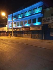 ItaquaquecetubaHotel Amora的街道边有蓝色灯光的建筑