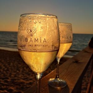 桑卢卡尔-德巴拉梅达PRECIOSO LOFT en PALACIO DE GODOY的两杯葡萄酒坐在沙滩上的桌子上