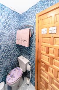布维翁La Casita del Árbol Blanco的一间带紫色卫生间和门的浴室
