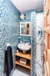 布维翁La Casita del Árbol Blanco的浴室设有蓝色瓷砖墙壁和水槽