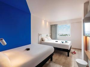 阿瓜斯卡连特斯ibis budget Aguascalientes Norte的酒店客房设有两张床和窗户。