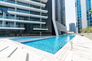 迪拜Ultimate Stay / 4 Beds / Burj Khalifa View / Ultra Modern / Business Bay的大楼前的游泳池