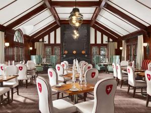 班夫费尔蒙班夫温泉酒店的用餐室配有桌子和白色椅子