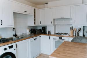 BranstonBluebell cottage Branston Lincoln的白色的厨房配有白色橱柜和水槽