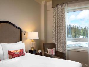 路易斯湖路易斯湖费尔蒙酒店的卧室配有床、椅子和窗户。
